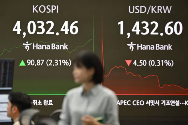 شاشة تُظهر مؤشر «كوسبي» وسعر صرف الوون الكوري مقابل الدولار في غرفة التداول بمقر بنك «هانا» في سيول (أ.ف.ب)