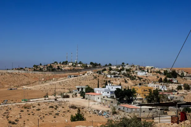 جدار فاصل بين قرية الرمادين والمستوطنة الإسرائيلية إشكولوت (رويترز)