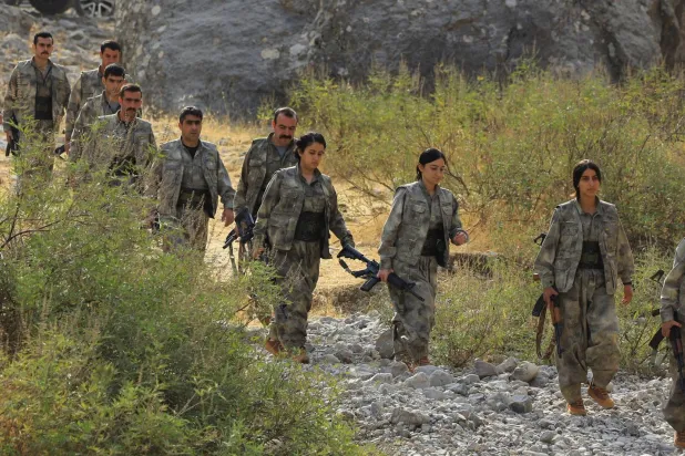 مجموعة من مسلحي حزب العمال الكردستاني أثناء مغادرتهم من تركيا إلى جبال قنديل في 26 أكتوبر (رويترز)