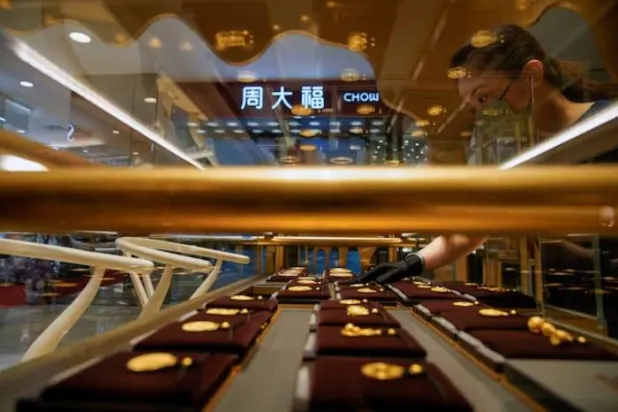 بائع يعرض مجوهرات «هيريتدج غولد» في متجر «تشو تاي فوك» بشنغهاي (رويترز)