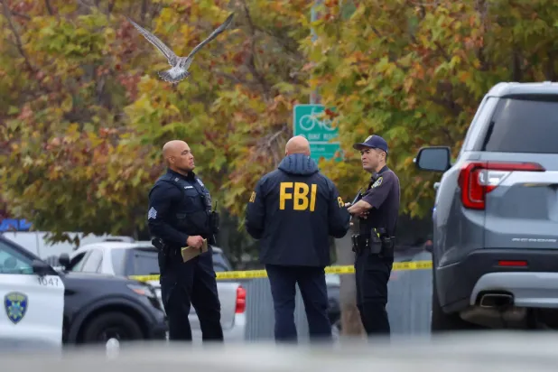 أحد عملاء «مكتب التحقيقات الفيدرالي» يتحدث إلى ضباط إنفاذ القانون في موقع إطلاق نار بكاليفورنيا (رويترز)