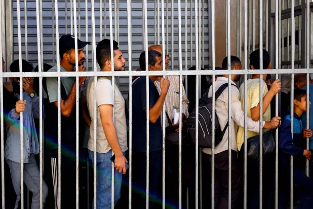 الناس يقفون في طوابير أمام «بنك فلسطين» وسط نقص في السيولة النقدية في النصيرات وسط قطاع غزة... 27 أكتوبر 2025 (رويترز)