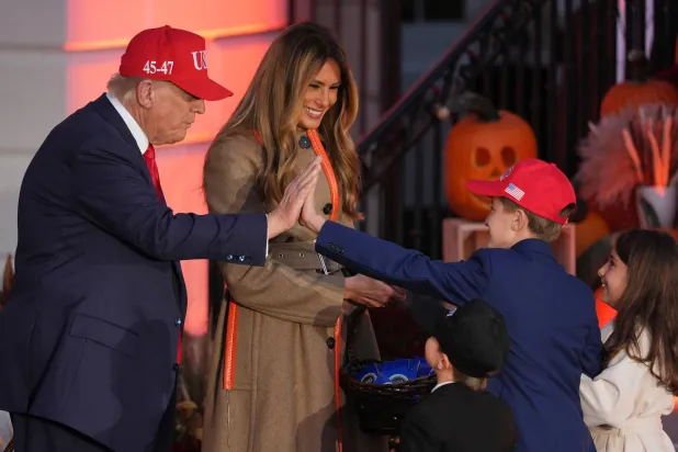 President Donald Trump, left, gives a high-five to a child dressed as him as first lady Melania Trump, second left, a child dressed as her, right, and a child dressed as a member of the Secret Service, third right, look on during a Halloween event on the South Lawn of the White House, Thursday, Oct. 30, 2025, in Washington. (AP) 