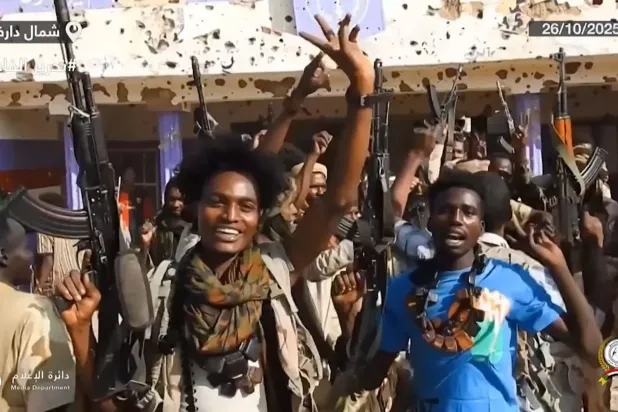 Sudan paramiliter örgütü HDK’nin Telegram hesabında 26 Ekim 2025'te paylaşılan bir videodan alınan karede, savaşçıların Darfur'daki El Faşir'e girdikten sonra sokaklarda silah taşıyıp kutlama yaptıkları görülüyor (AFP).