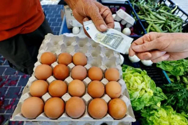 يدفع أحد الزبائن خمسة يوروهات لشراء البيض في إحدى الأسواق المحلية في نيس (رويترز)