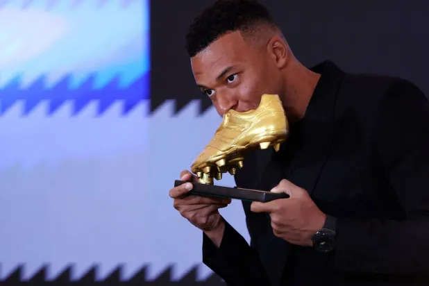 مبابي يُقبّل الجائزة لحظة تسلمه إياها (رويترز)