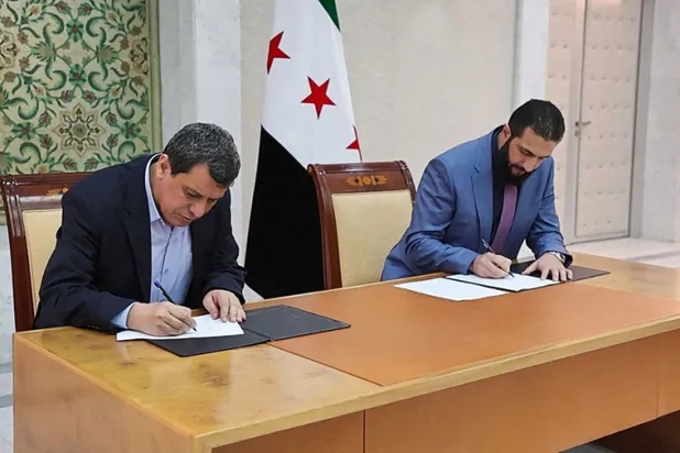 Suriye Cumhurbaşkanı Ahmed el-Şeraa (sağda) ve SDG Başkomutanı Mazlum Abdi, Şam’da SDG'yi devlet kurumlarına entegre etmeyi öngören bir anlaşma imzalarken, 10 Mart 2025 (AFP)