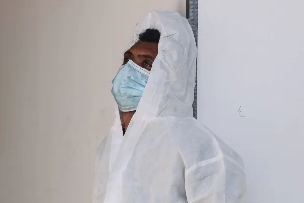 موظف في «مجمع ناصر الطبي» يستريح بالقرب من كيس جثث يحتوي على إحدى الجثث الثلاثين لأسرى فلسطينيين احتجزتهم إسرائيل وأفرجت عنهم كجزء من صفقة تبادل الأسرى عند وصولهم إلى خان يونس (أ.ف.ب)