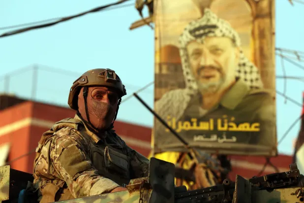 عنصر في الجيش اللبناني على متن آلية عسكرية على مدخل مخيم برج البراجنة للاجئين الفلسطينيين جنوب بيروت (إ.ب.أ)