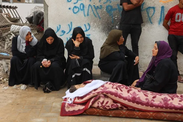 Palestinians mourn a relative killed in Israeli airstrikes in Gaza City (AFP)