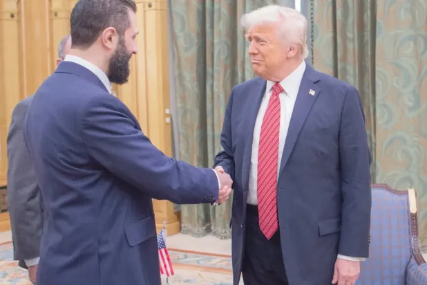 ABD Başkanı Donald Trump, 14 Mayıs'ta Riyad'da Suriye Cumhurbaşkanı Ahmed eş-Şara ile tokalaşırken (AP)