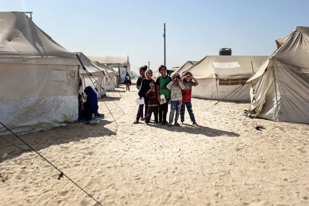 أطفال فلسطينيون بينهم يتامى في مخيم البريج للنازحين بوسط قطاع غزة (د.ب.أ)