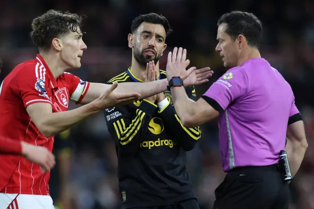 لاعب نوتنغهام رايان ييتس ولاعب يونايتد برونو فيرنانديز يحتجان على الحكم دارين إنغلاند (أ.ف.ب)