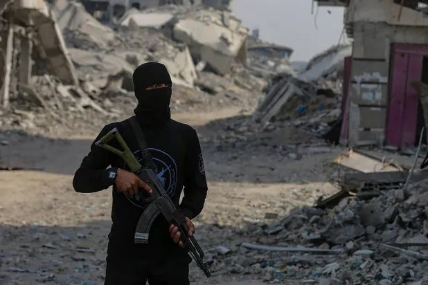 أحد عناصر «كتائب القسام» يقف قرب أحد مواقع البحث عن رفات الرهائن الإسرائيليين في قطاع غزة (إ.ب.أ)
