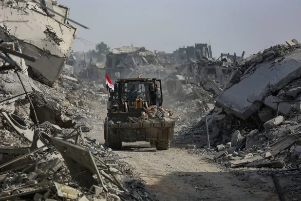 آلية تشارك في عملية البحث عن جثث الرهائن الإسرائيليين وسط الركام بشرق قطاع غزة يوم الأحد (إ.ب.أ)
