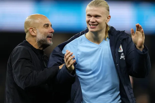 إيرلينغ هالاند يحتفل مع مدربه بيب غوارديولا بالفوز على بورنموث (إ.ب.أ)