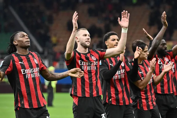 فرحة لاعبي ميلان مع جماهيرهم بالفوز على روما (أ.ف.ب)