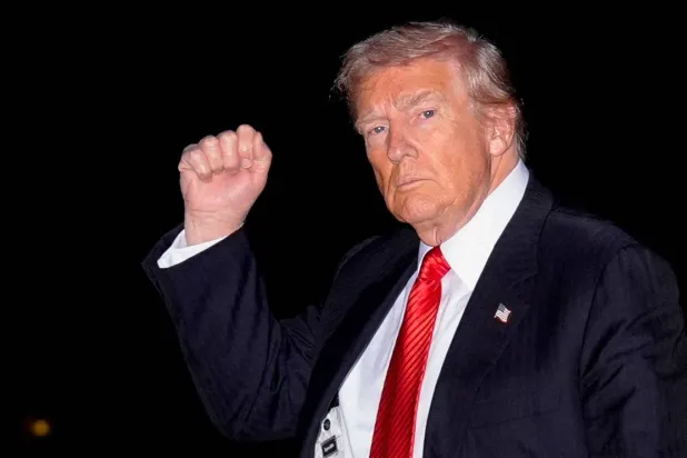 الرئيس الأميركي دونالد ترمب يلوّح للمصورين خلال عودته للبيت الأبيض بعد قضاء عطلة نهاية الأسبوع في فلوريدا (رويترز)