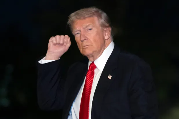 دونالد ترمب يُشير بيده خلال سيره في البيت الأبيض (أ.ب)