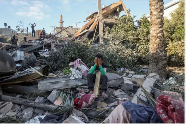 طفل يجلس وسط أنقاض منزل دمّره القصف الإسرائيلي في النصيرات وسط قطاع غزة (أ.ف.ب)