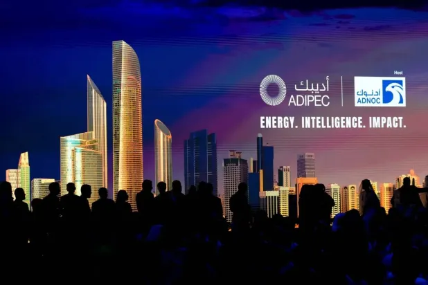 Delegates are silhouetted against a screen as they attend the inaugural session of ADIPEC in Abu Dhabi on Monday. (AP) 