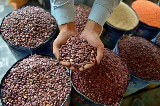  رجل يبيع الفاصوليا الحمراء بسوق جملة في باكستان (إ.ب.أ)