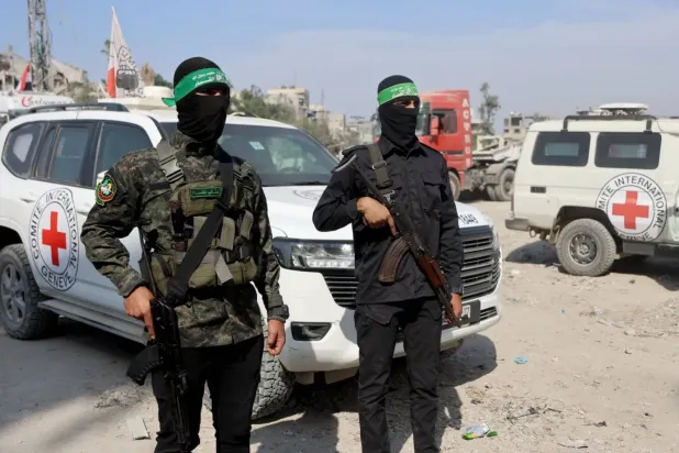 Gazze şehrinde İsrailli rehinelerin cesetlerini arama çalışmaları sırasında Uluslararası Kızılhaç Komitesi (ICRC) araçlarının yanında nöbet tutan Hamas mensupları (AFP)