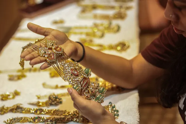 امرأة هندية تستعرض مجوهرات ذهبية في متجر بمومباي (إ.ب.أ)