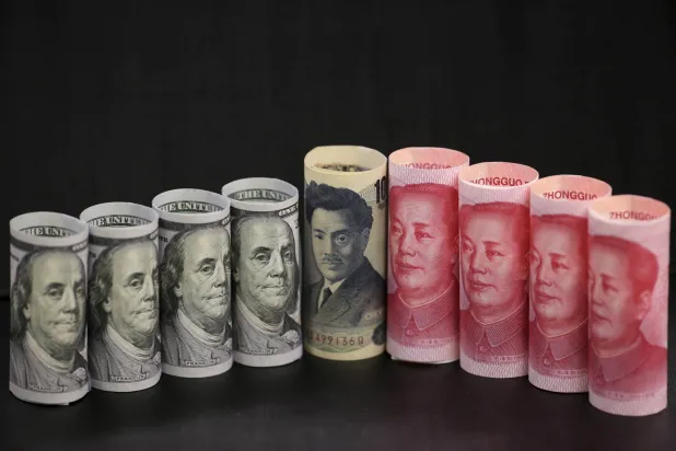 أوراق نقدية من فئة 100 دولار أميركي و100 يوان صيني و1000 ين ياباني (رويترز)