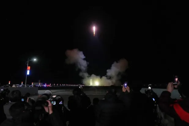 Journalists film China's Long March 2F rocket, carrying three astronauts for the Shenzhou 21 manned space mission, lifts off for a space station, at the Jiuquan Satellite Launch Center in Jiuquan, northwestern China, Friday, Oct. 31, 2025. (AP)