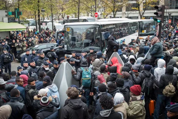 أشخاص ينتظرون ركوب الحافلات أثناء إخلاء مخيم مؤقت في باريس (إ.ب.أ - أرشيفية)