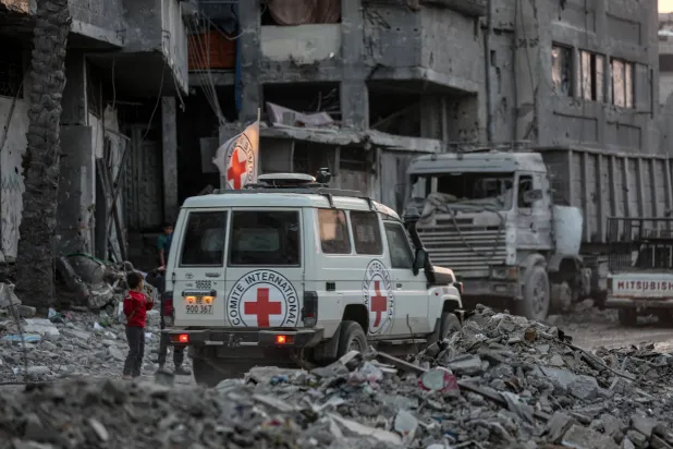 مقاتلو «حماس» وأعضاء اللجنة الدولية للصليب الأحمر يبحثون عن جثث الرهائن الإسرائيليين في مدينة غزة (د.ب.أ) 