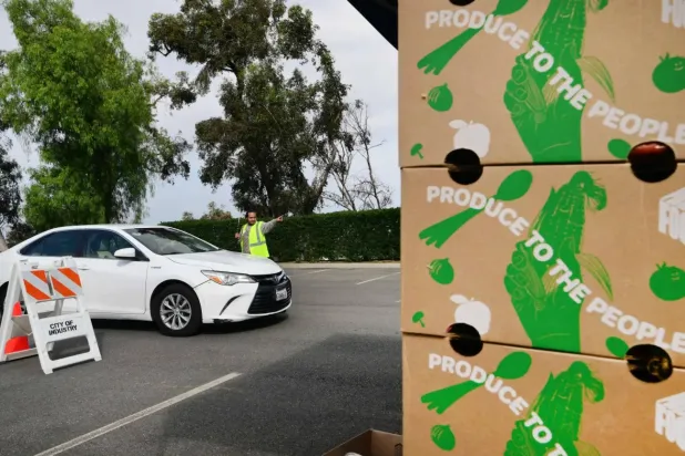 Los Angeles'taki bir gıda bankası, ihtiyaç sahibi Amerikalılara yardım dağıtırken (AFP)