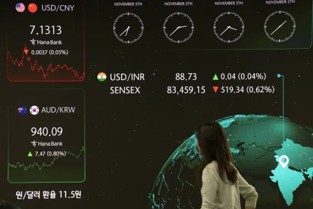 متداول يعمل أمام شاشات المراقبة بغرفة التداول لبنك هانا في سيول (إ.ب.أ)