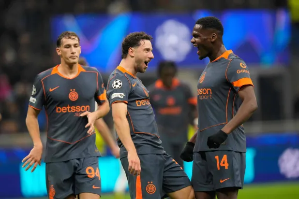 كارلوس أوغوستو لاعب إنتر ميلان يحتفل مع زملائه بعد تسجيله الهدف الثاني (أ.ب)