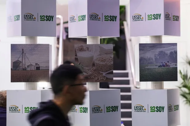 رجل يمر بجناح مجلس تصدير فول الصويا الأميركي بمعرض الصين الدولي الثامن للواردات في شنغهاي (رويترز)