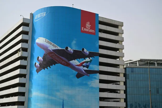 A billboard advertising the national flag carrier of the United Arab Emirates, Emirates Airways, hangs from a building near Dubai International Airport, in Dubai on November 6, 2025. (Photo by Giuseppe CACACE / AFP)