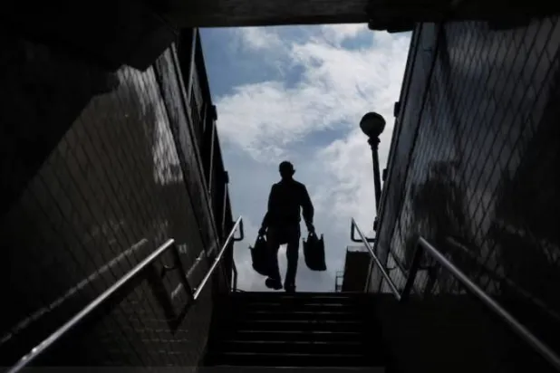رجل ينزل إلى مدخل محطة مترو في منطقة تشاينا تاون بمدينة نيويورك (رويترز)