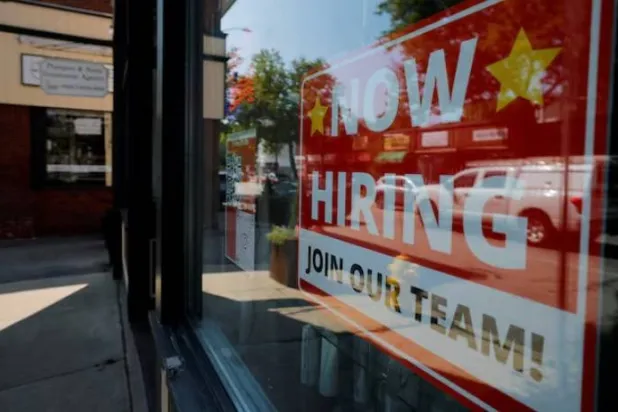 لافتة «نحن نوظف» مُعلّقة على نافذة صالون حلاقة في مدينة ميدفورد الكبرى بولاية ماساتشوستس (رويترز)