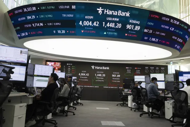 يتابع سماسرة عملهم أمام شاشات المراقبة في بنك هانا بسيول (إ.ب.أ)