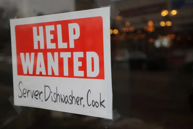 FILE PHOTO: A “Help Wanted” sign hangs in restaurant window in Medford, Massachusetts, US, January 25, 2023. REUTERS/Brian Snyder/File Photo