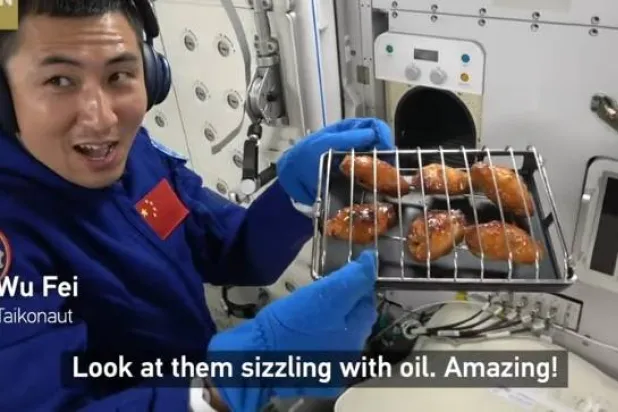 رائد الفضاء وو في وصف أجنحة الدجاج المطبوخة حديثاً بأنها «ذات اللون والرائحة والنكهة المثالية» (يوتيوب)