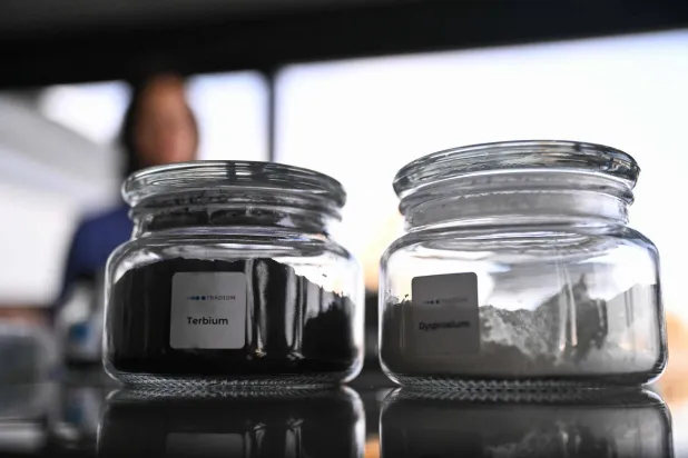 A glass jar containing the rare earth metal Terbium (L) is pictured inside the storage room of Tradium, a company specialised in trading rare earths, in Frankfurt am Main, western Germany, on November 4, 2025. (Photo by Kirill KUDRYAVTSEV / AFP)