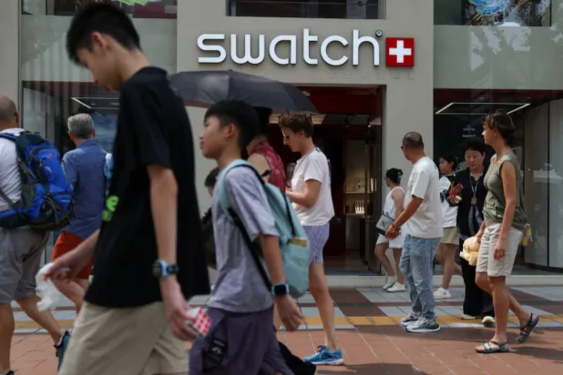 People walk past a store of Swiss watchmaker Swatch, in Beijing, China August 18, 2025. REUTERS/Tingshu Wang/File Photo 