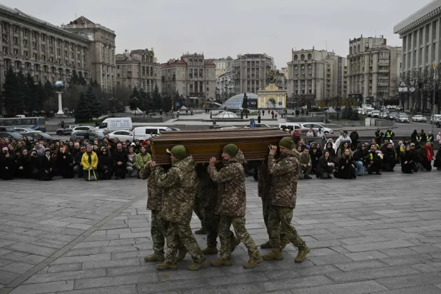  جنود من حرس الشرف يحملون نعش الجندي الأوكراني (أ.ف.ب)