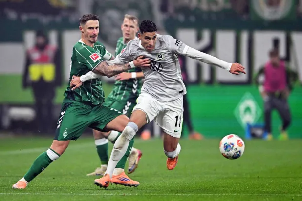 البرتغالي تياغو توماس من فولفسبورغ يتنافس على الكرة مع ماركو فريدل لاعب فيردر بريمن (أ.ب).