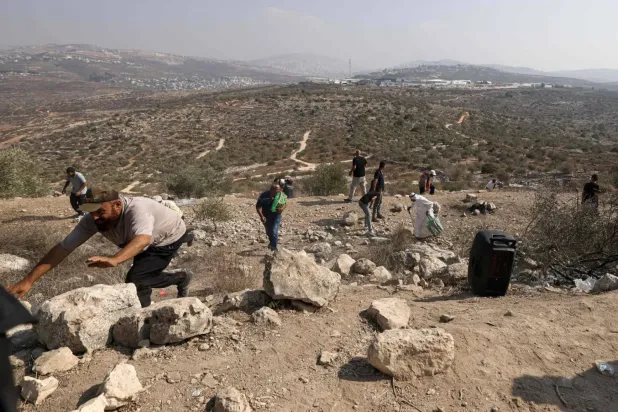 İşgal altındaki Batı Şeria'da, Nablus'un doğusunda yerleşimcilerin topraklarına el koymasını protesto eden Filistinliler, dün İsrail ordusunun attığı gaz bombalarından kaçıyor (AFP)