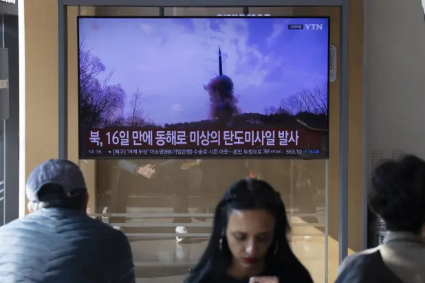 مواطنون يشاهدون الأخبار على شاشة تلفزيون في محطة بسيول إذ أطلقت كوريا الشمالية صاروخاً باليستياً باتجاه البحر الشرقي (إ.ب.أ)