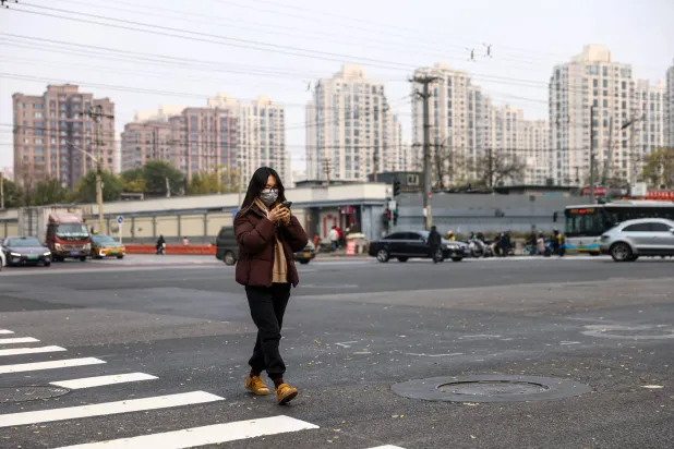 A woman wearing a face mask walks on a street in Beijing, China, 06 November 2025.  EPA/WU HAO