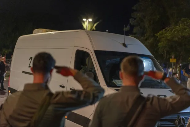 جنديان إسرائيليان يؤديان التحية لعربة تنقل جثث رهائن أعيدت من قطاع غزة الشهر الماضي (د.ب.أ)